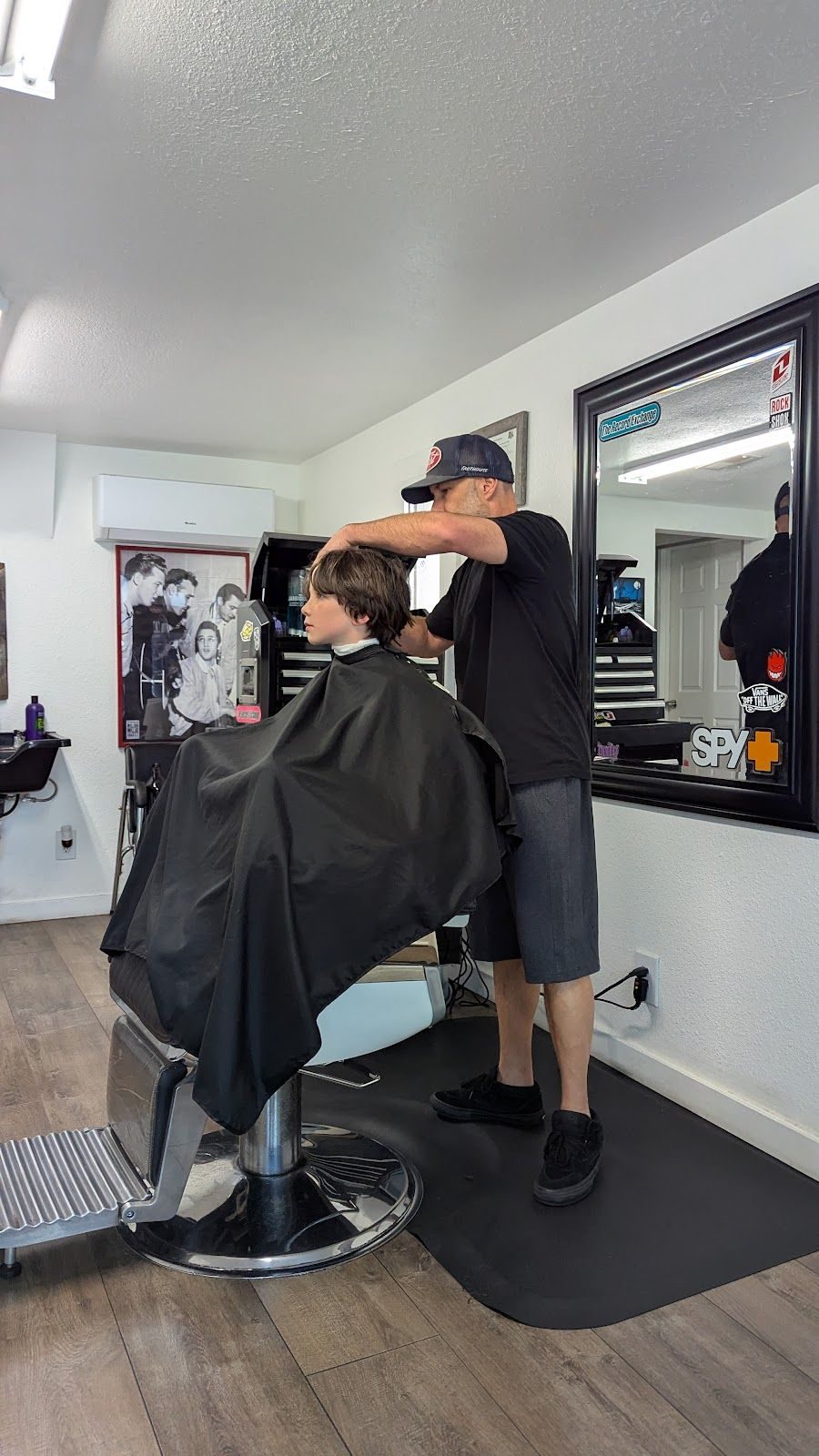 Travis Keller cutting a client's hair inside UpperKutz